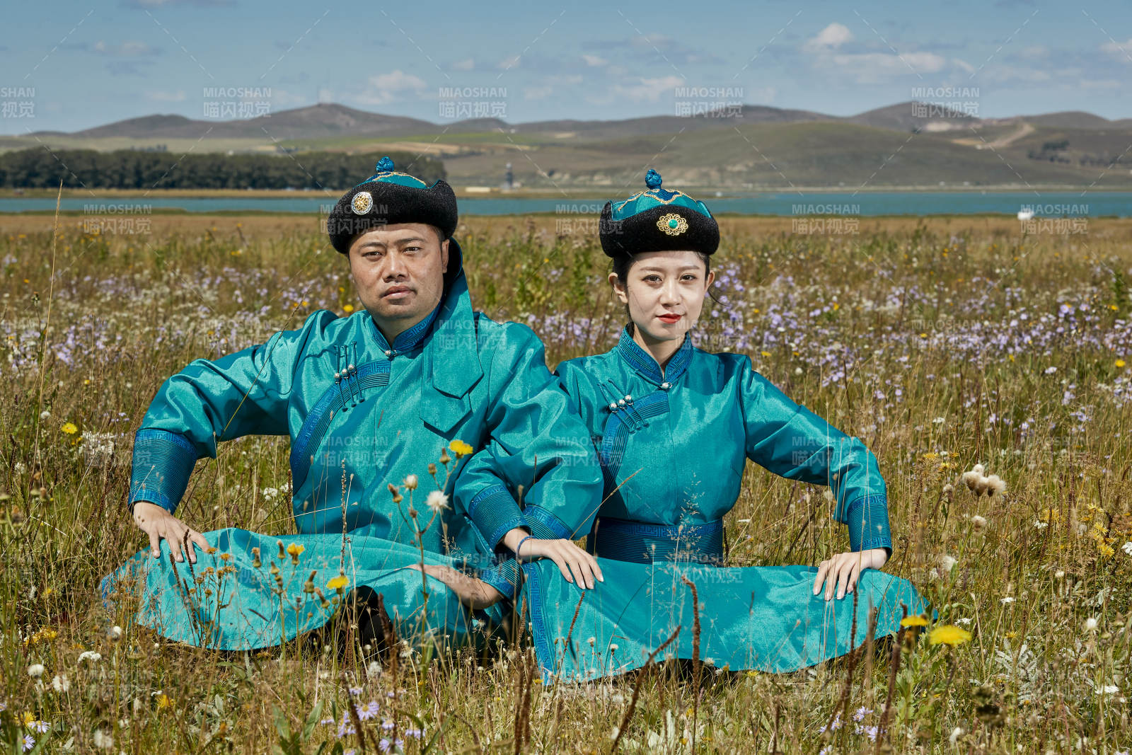 草原上蒙古包前穿蒙古族传统服饰的年轻夫妻图片