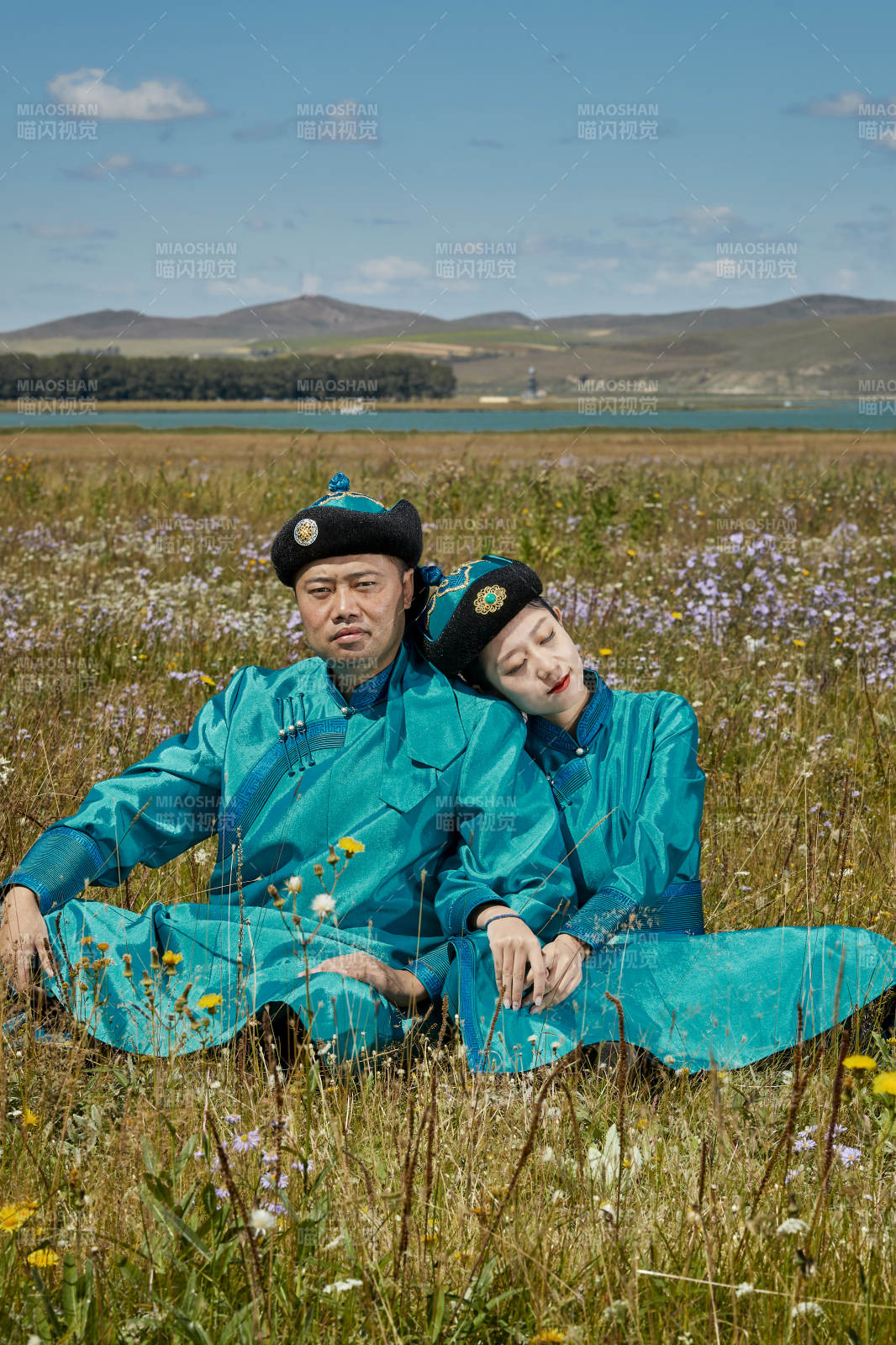 草原上蒙古包前穿蒙古族传统服饰的年轻夫妻图片