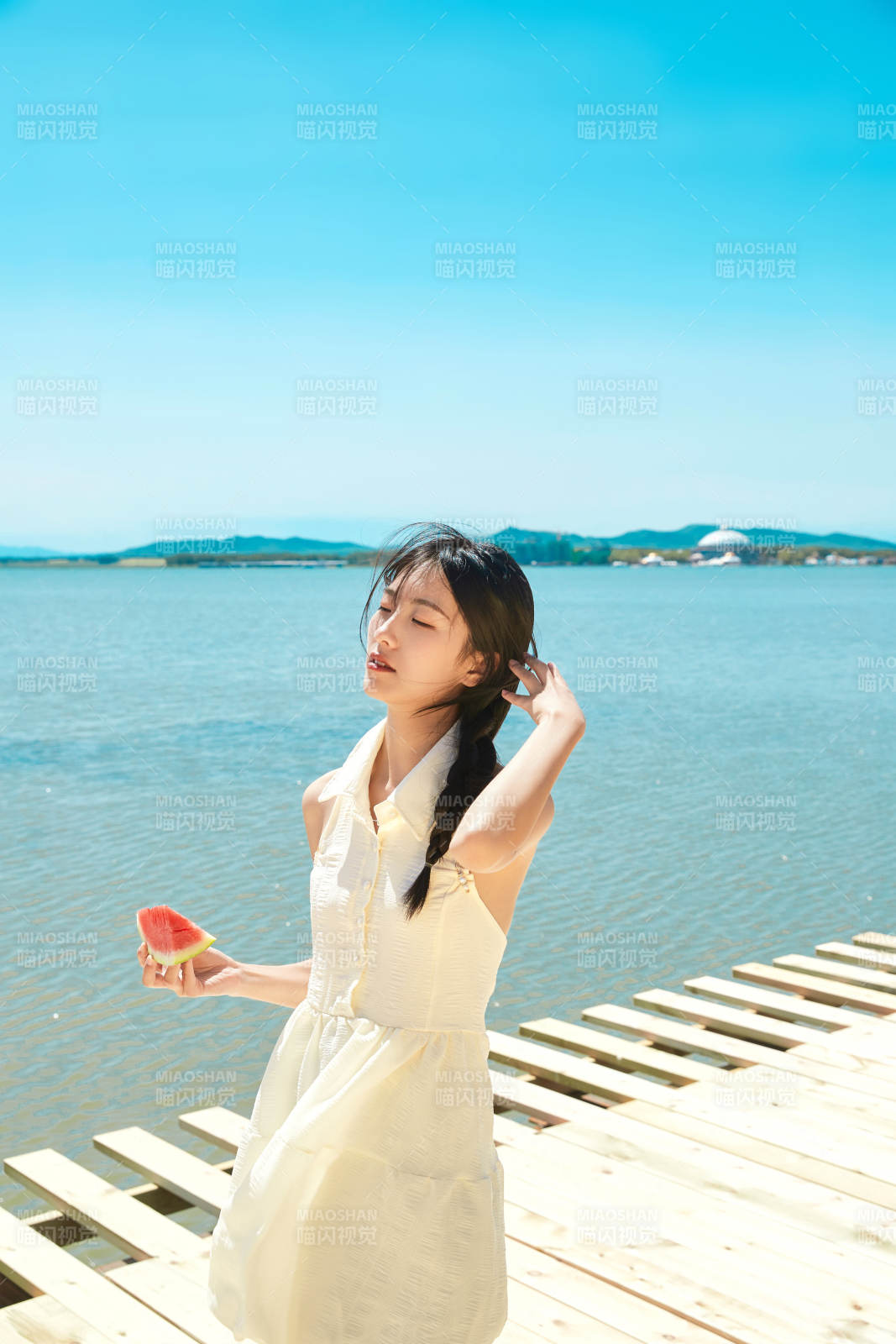 夏日户外湖边彩色公路上玩耍吃西瓜的少女图片