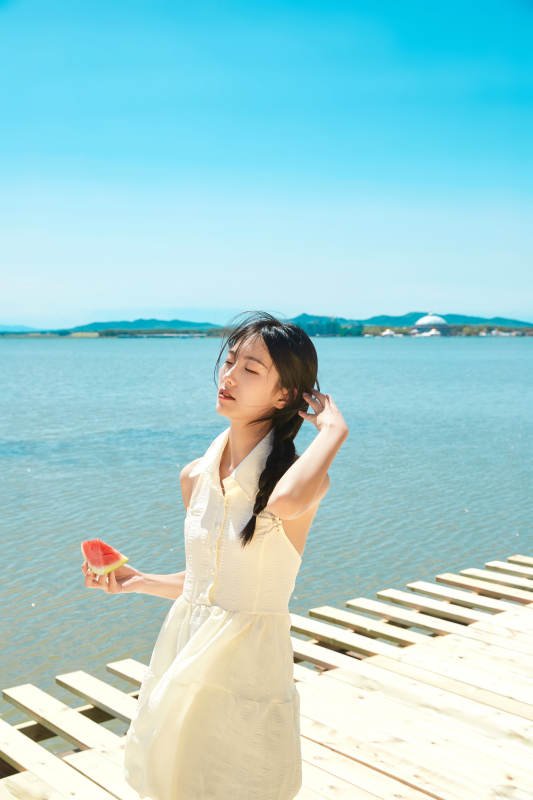 夏日户外湖边彩色公路上玩耍吃西瓜的少女图片