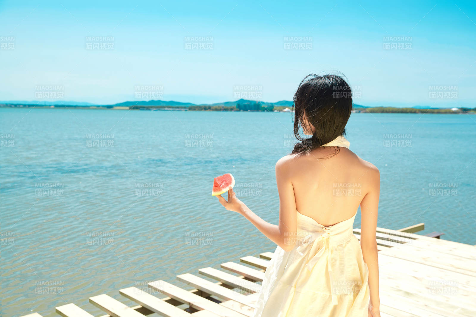 夏日户外湖边彩色公路上玩耍吃西瓜的少女图片