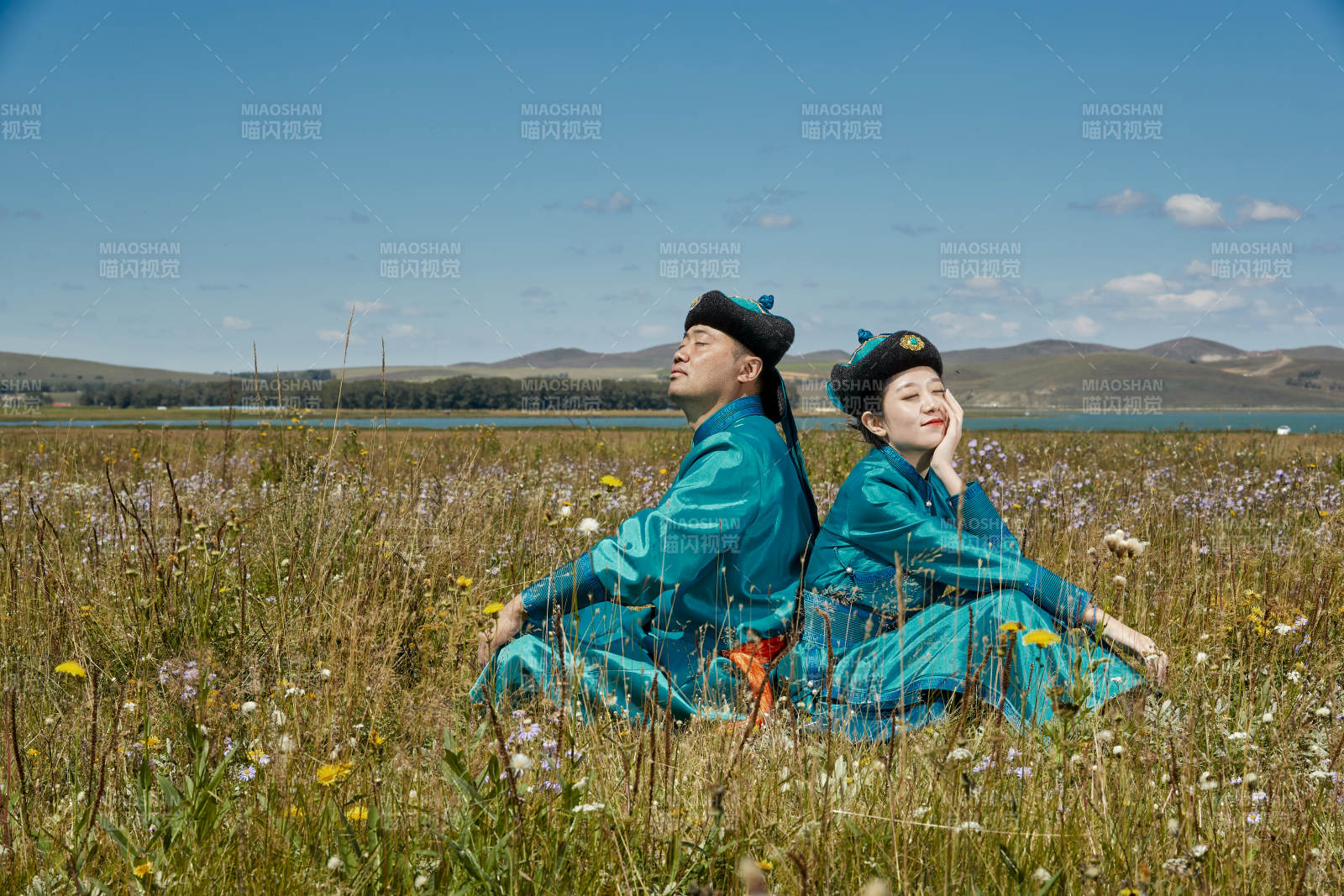 草原上蒙古包前穿蒙古族传统服饰的年轻夫妻图片