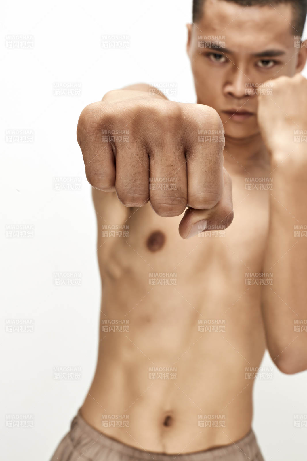 白色背景下演示自由搏击动作的亚洲功夫男性图片