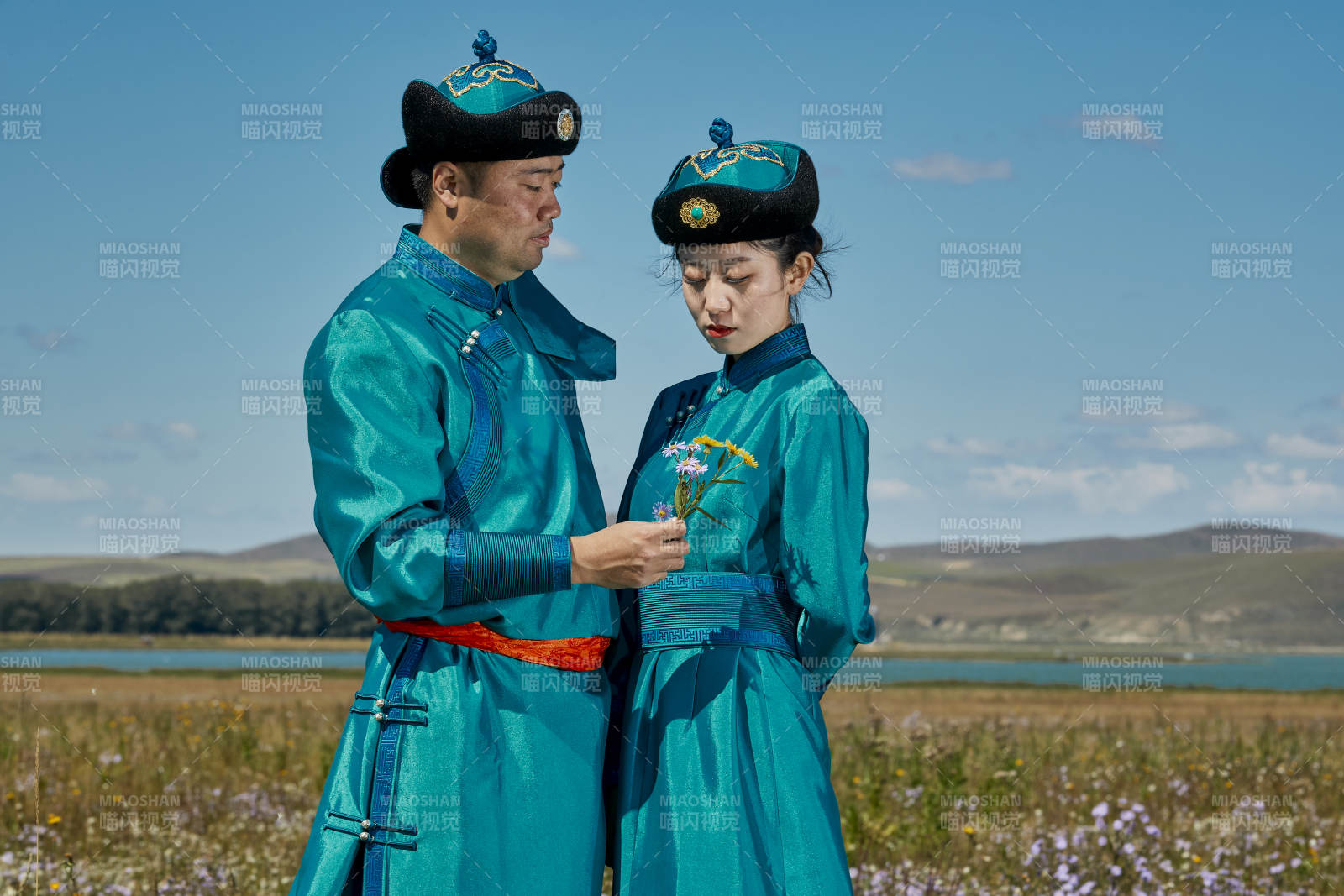 草原上蒙古包前穿蒙古族传统服饰的年轻夫妻图片