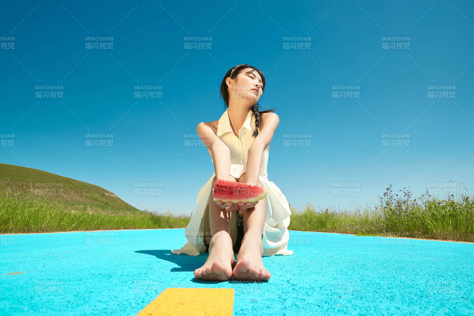 夏日户外湖边彩色公路上玩耍吃西瓜的少女图片