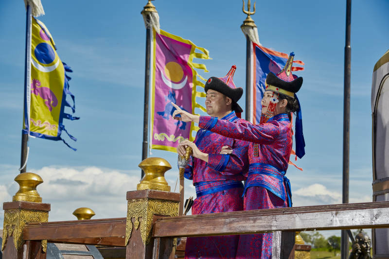 草原上蒙古包前穿蒙古族传统服饰的年轻夫妻图片