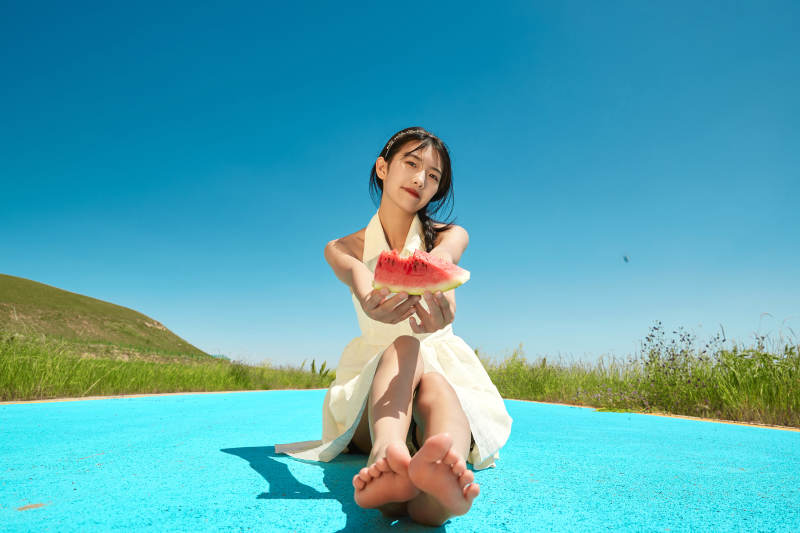 夏日户外湖边彩色公路上玩耍吃西瓜的少女图片