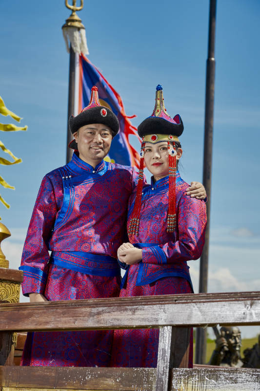 草原上蒙古包前穿蒙古族传统服饰的年轻夫妻图片