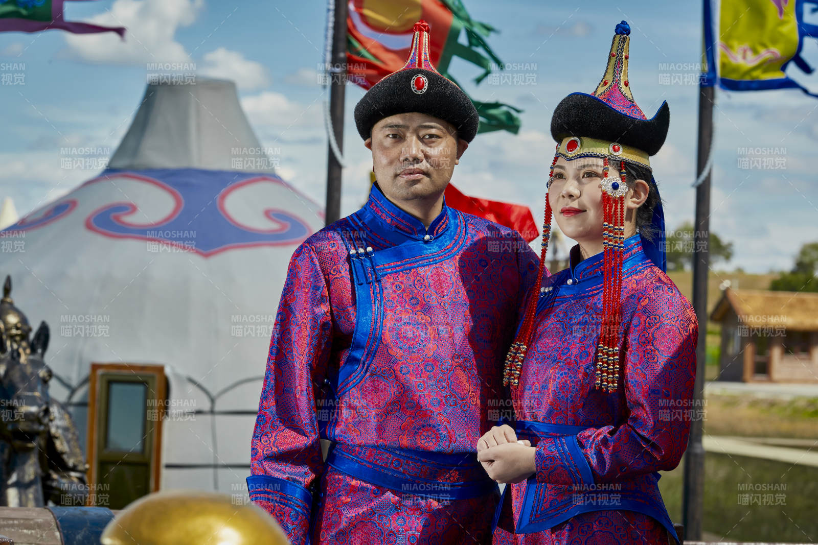 草原上蒙古包前穿蒙古族传统服饰的年轻夫妻图片