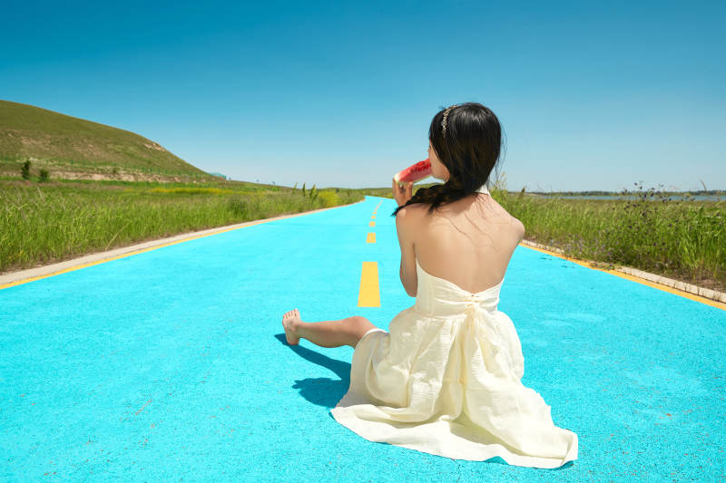 夏日户外湖边彩色公路上玩耍吃西瓜的少女图片