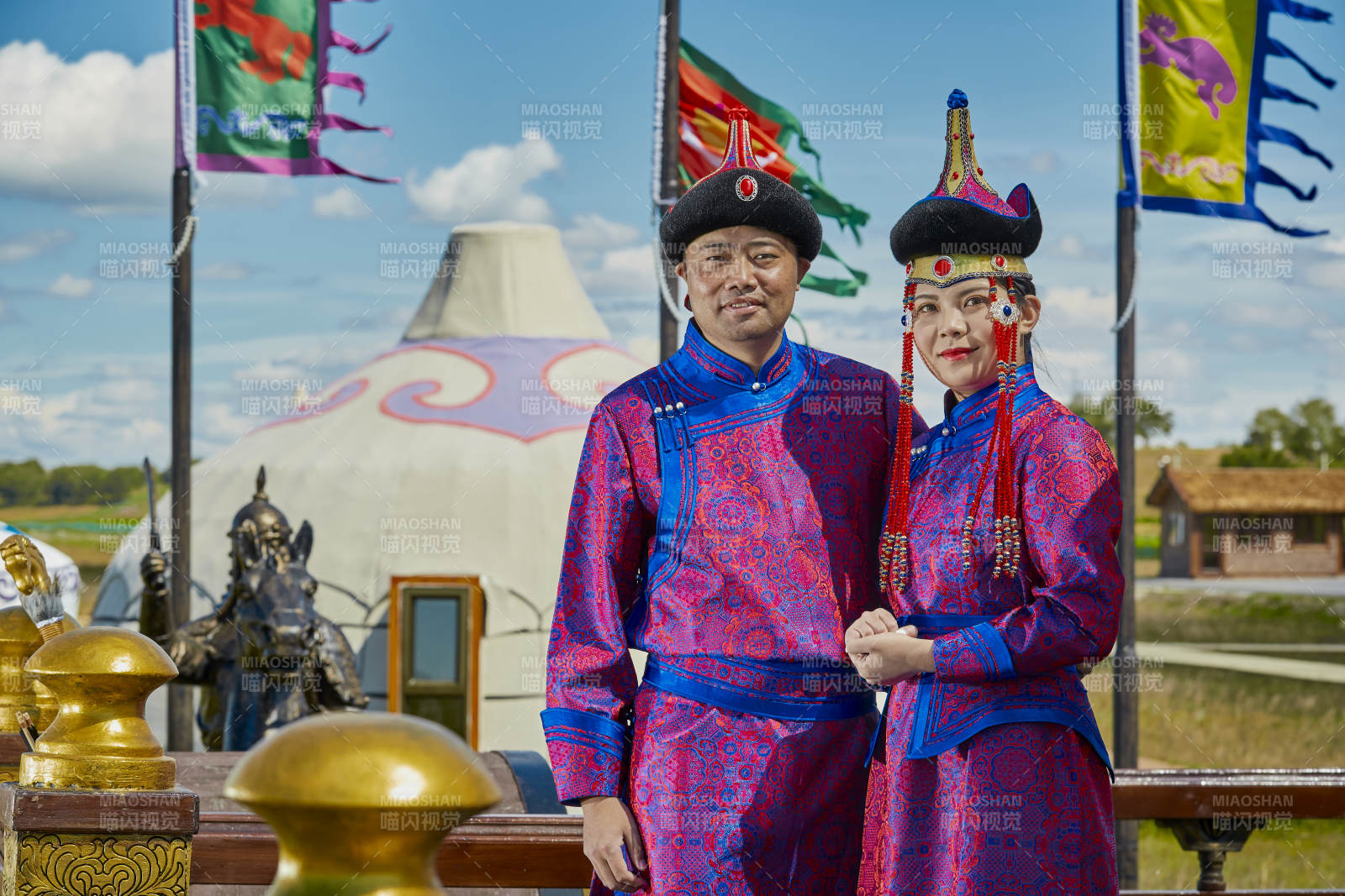 草原上蒙古包前穿蒙古族传统服饰的年轻夫妻图片