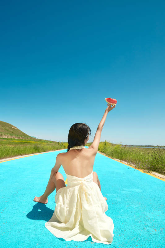 夏日户外湖边彩色公路上玩耍吃西瓜的少女图片