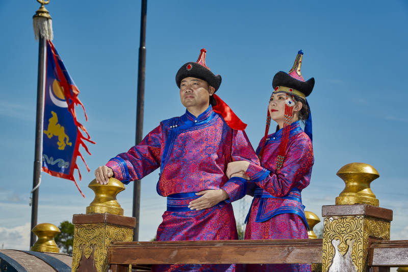 草原上蒙古包前穿蒙古族传统服饰的年轻夫妻图片