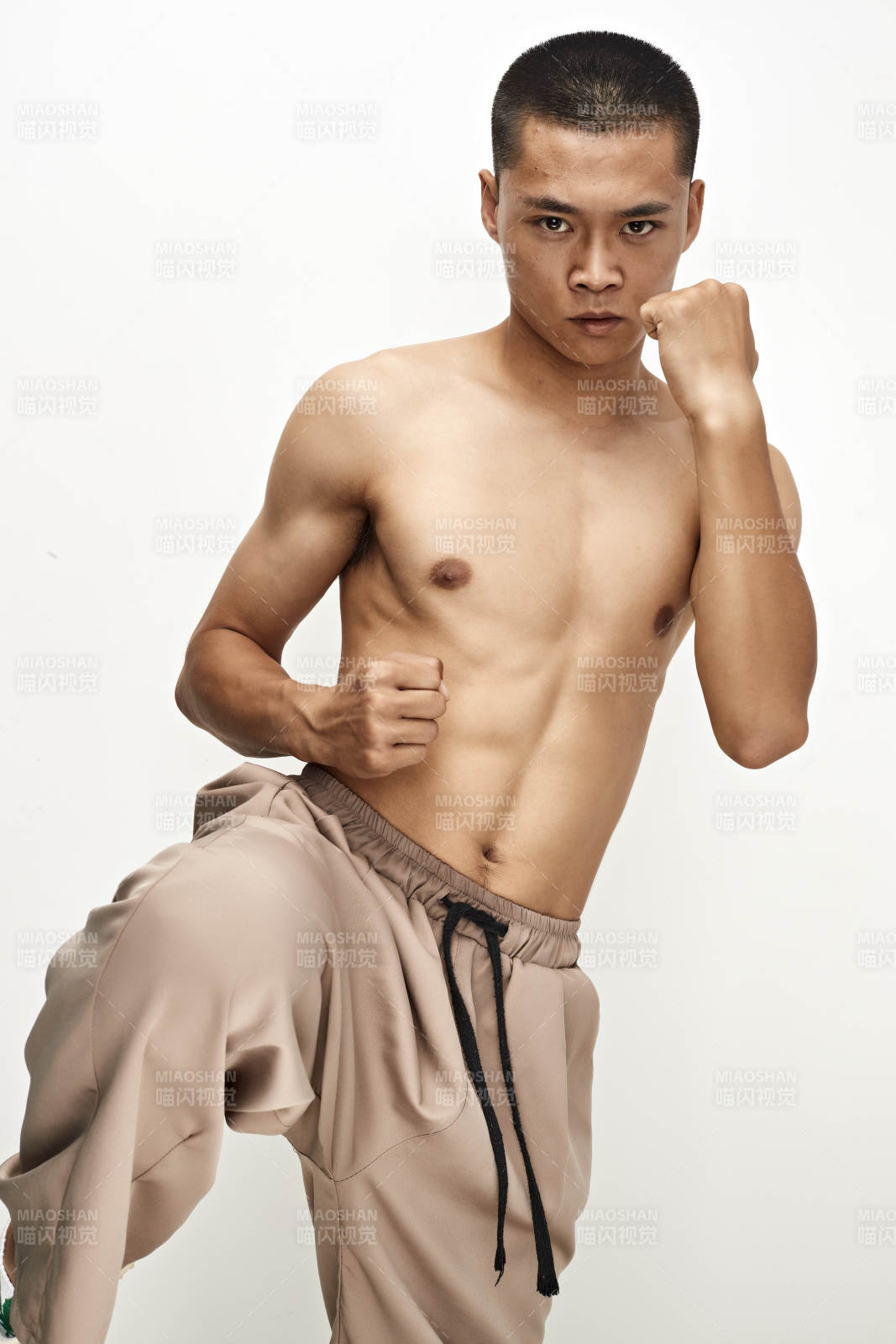 白色背景下演示自由搏击动作的亚洲功夫男性图片