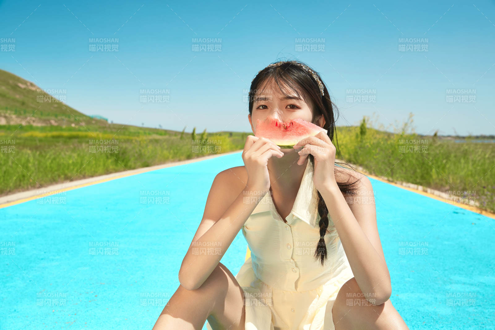 夏日户外湖边彩色公路上玩耍吃西瓜的少女图片
