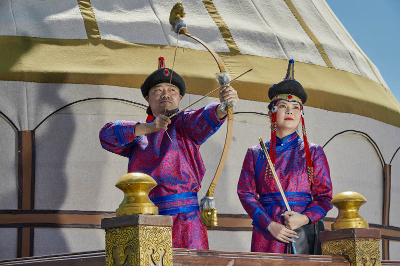 草原上蒙古包前穿蒙古族传统服饰的年轻夫妻图片