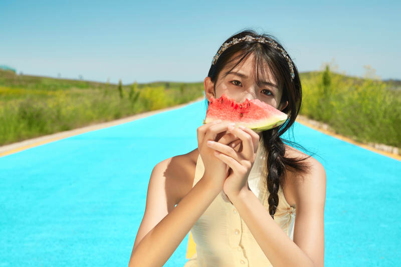 夏日户外湖边彩色公路上玩耍吃西瓜的少女图片