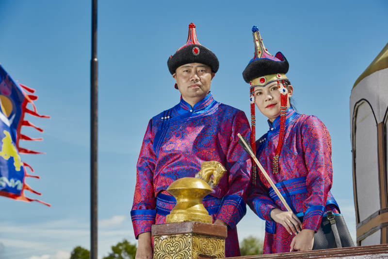 草原上蒙古包前穿蒙古族传统服饰的年轻夫妻图片