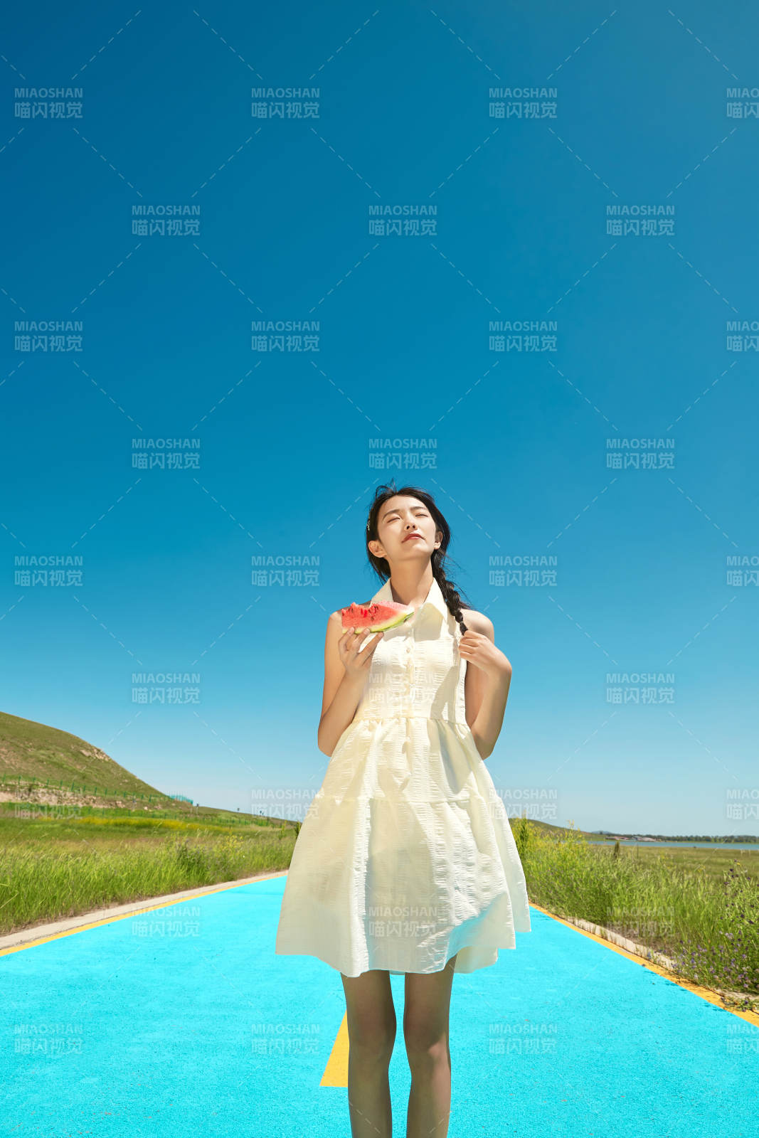 夏日户外湖边彩色公路上玩耍吃西瓜的少女图片