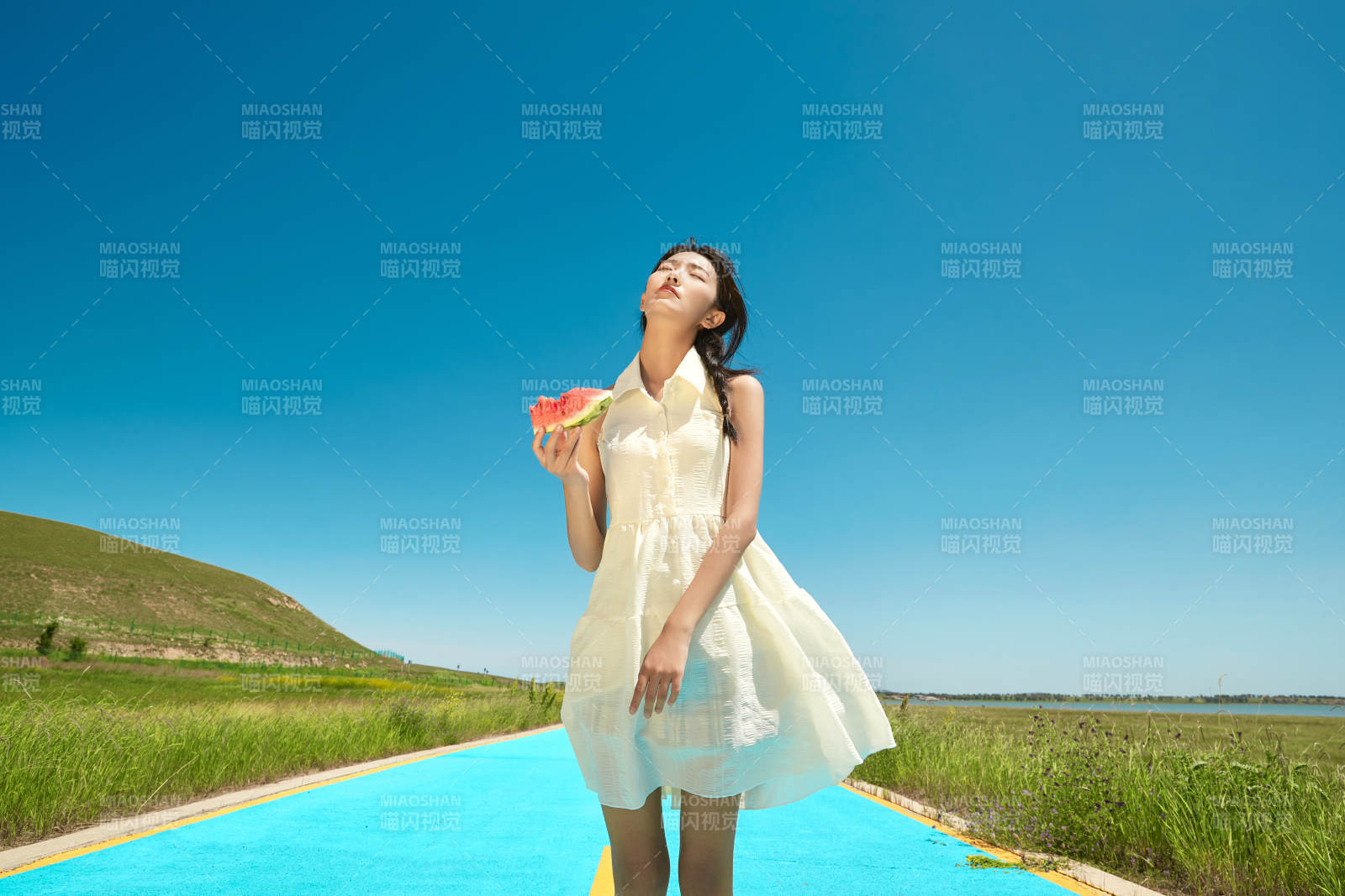 夏日户外湖边彩色公路上玩耍吃西瓜的少女图片