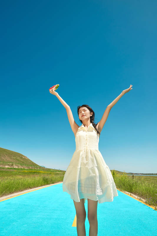 夏日户外湖边彩色公路上玩耍吃西瓜的少女图片