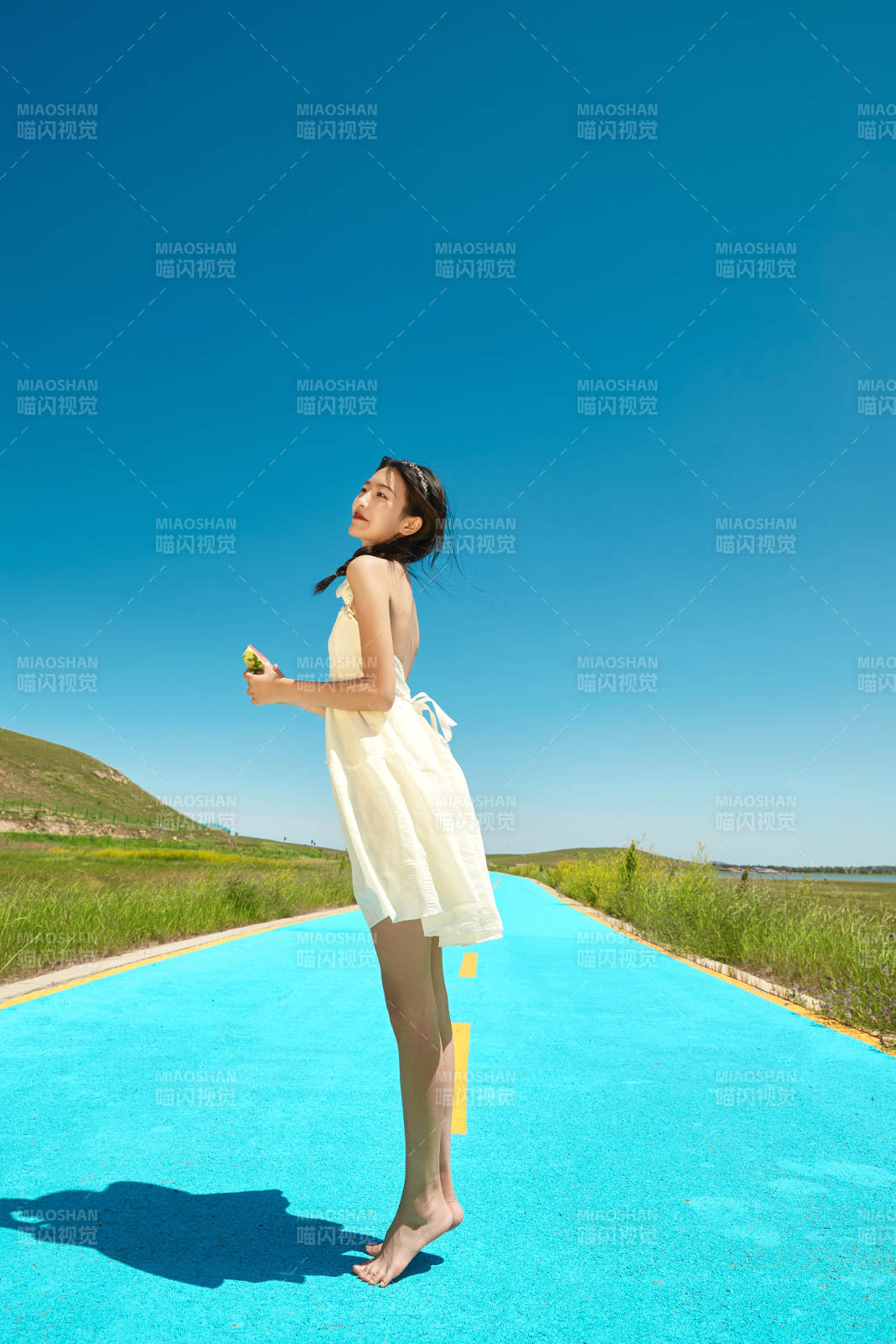 夏日户外湖边彩色公路上玩耍吃西瓜的少女图片