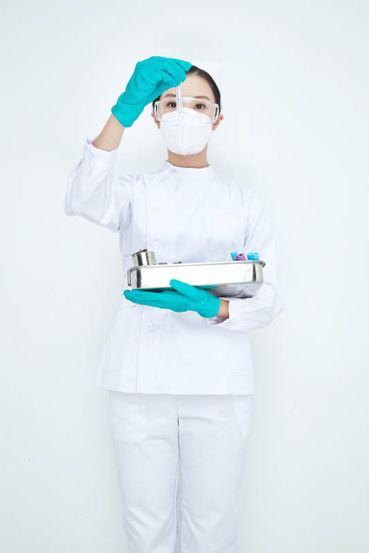 身穿护士服手抱化验托盘的年轻女护士图片