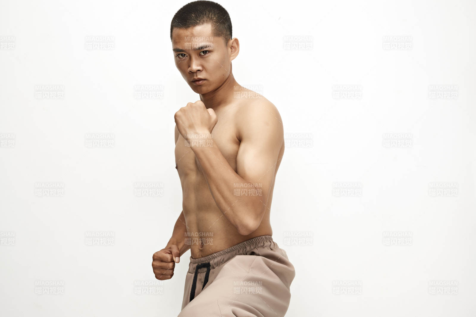 白色背景下演示自由搏击动作的亚洲功夫男性图片