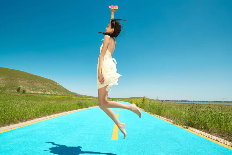 夏日户外湖边彩色公路上玩耍吃西瓜的少女图片