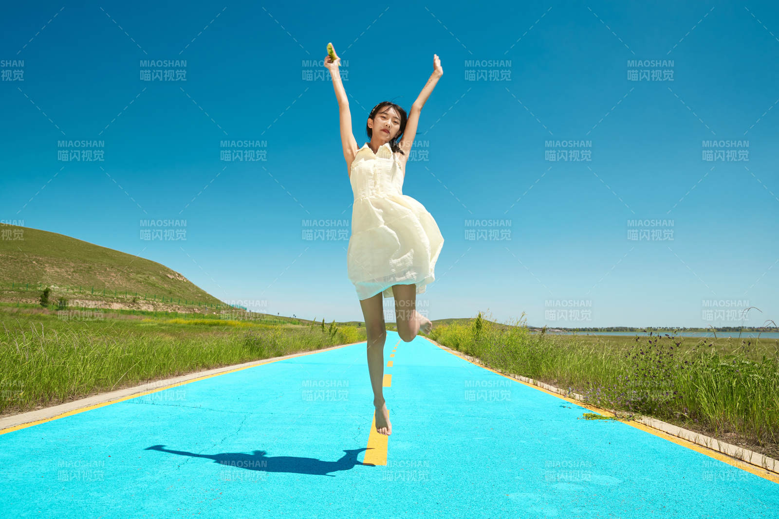 夏日户外湖边彩色公路上玩耍吃西瓜的少女图片