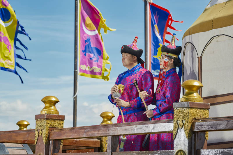 草原上蒙古包前穿蒙古族传统服饰的年轻夫妻图片