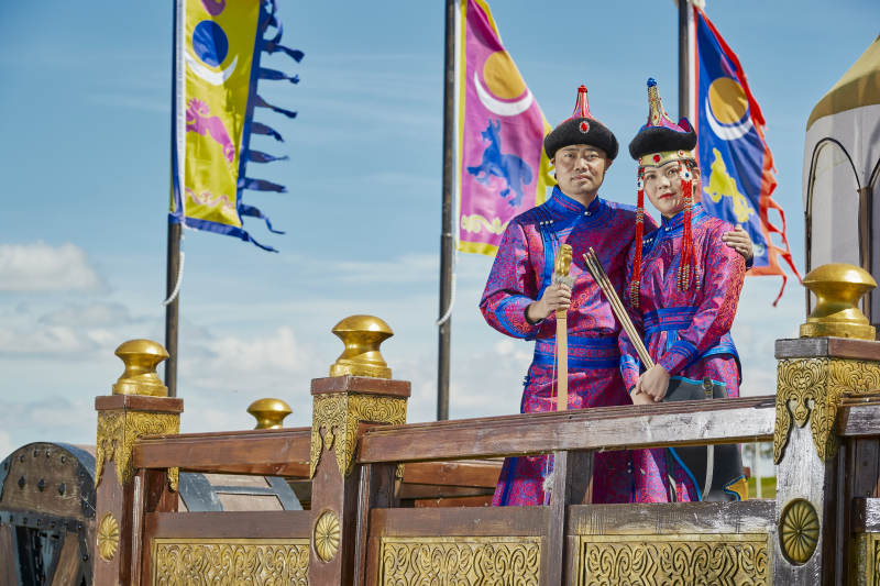 草原上蒙古包前穿蒙古族传统服饰的年轻夫妻图片