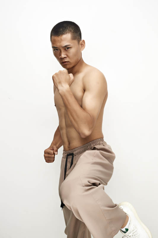 白色背景下演示自由搏击动作的亚洲功夫男性图片