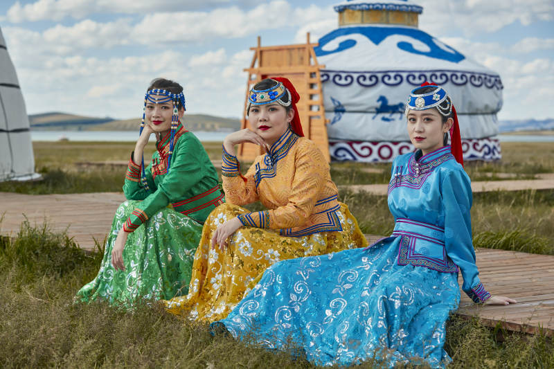 草原上穿着蒙古族传统服饰的亚洲年轻女性图片