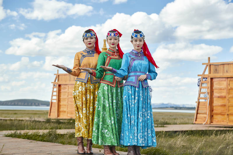 草原上穿着蒙古族传统服饰的亚洲年轻女性图片