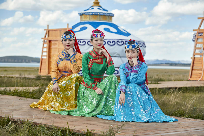 草原上穿着蒙古族传统服饰的亚洲年轻女性图片