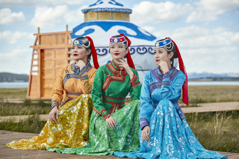 草原上穿着蒙古族传统服饰的亚洲年轻女性图片