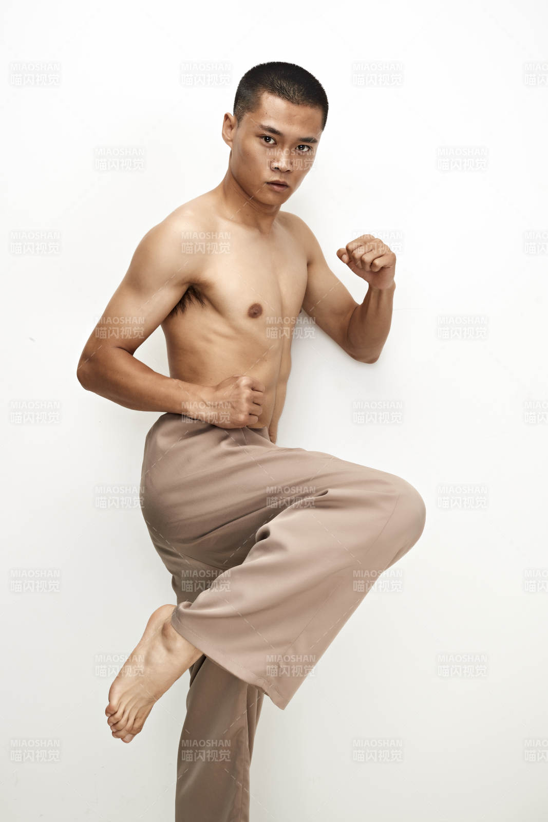 白色背景下演示自由搏击动作的亚洲功夫男性图片