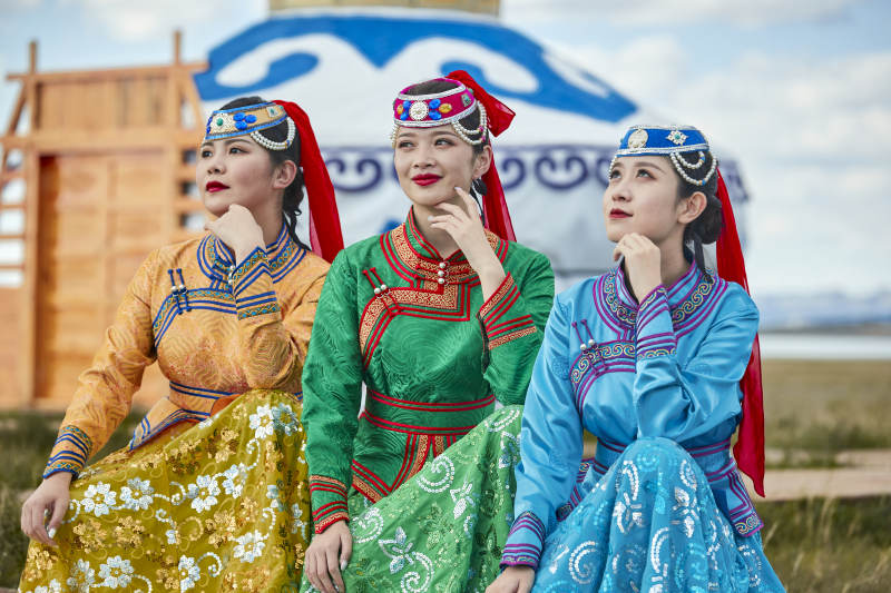 草原上穿着蒙古族传统服饰的亚洲年轻女性图片