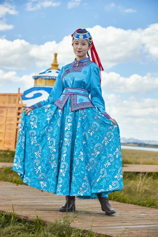 草原上穿着蒙古族传统服饰的亚洲年轻女性图片