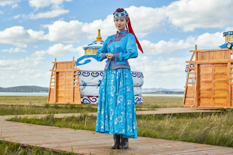 草原上穿着蒙古族传统服饰的亚洲年轻女性图片