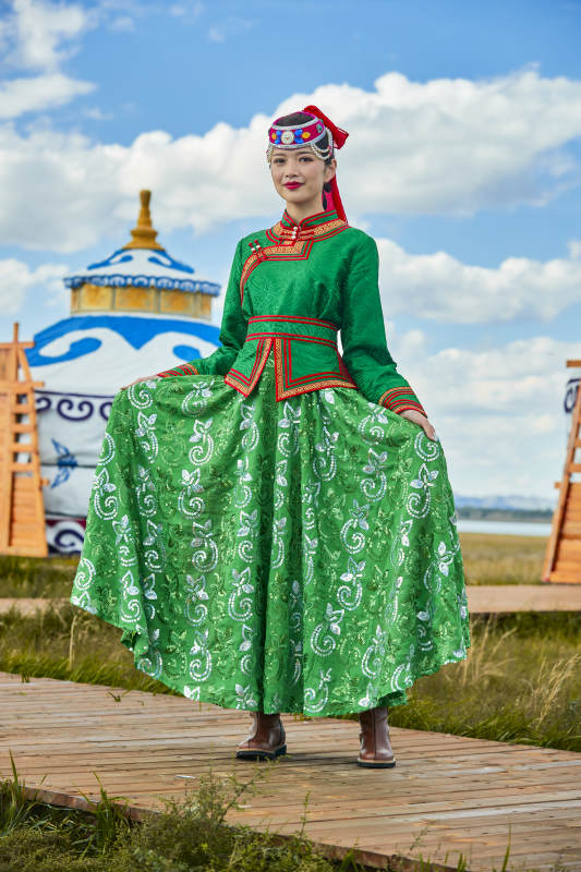 草原上穿着蒙古族传统服饰的亚洲年轻女性图片