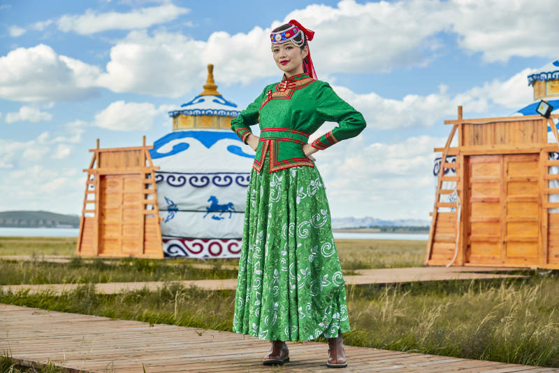 草原上穿着蒙古族传统服饰的亚洲年轻女性图片