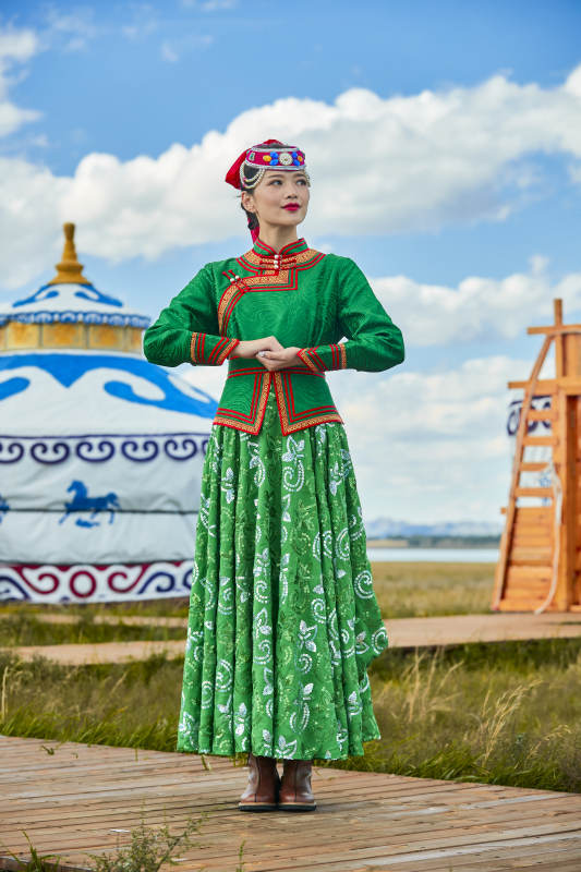 草原上穿着蒙古族传统服饰的亚洲年轻女性图片