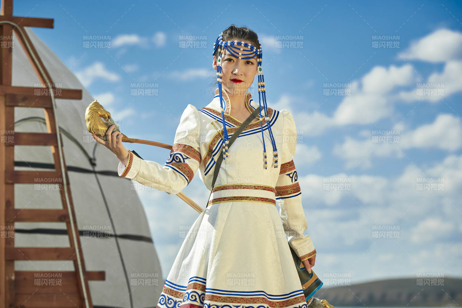 草原湖畔身穿蒙古族饰手持弓箭的蒙族少女图片