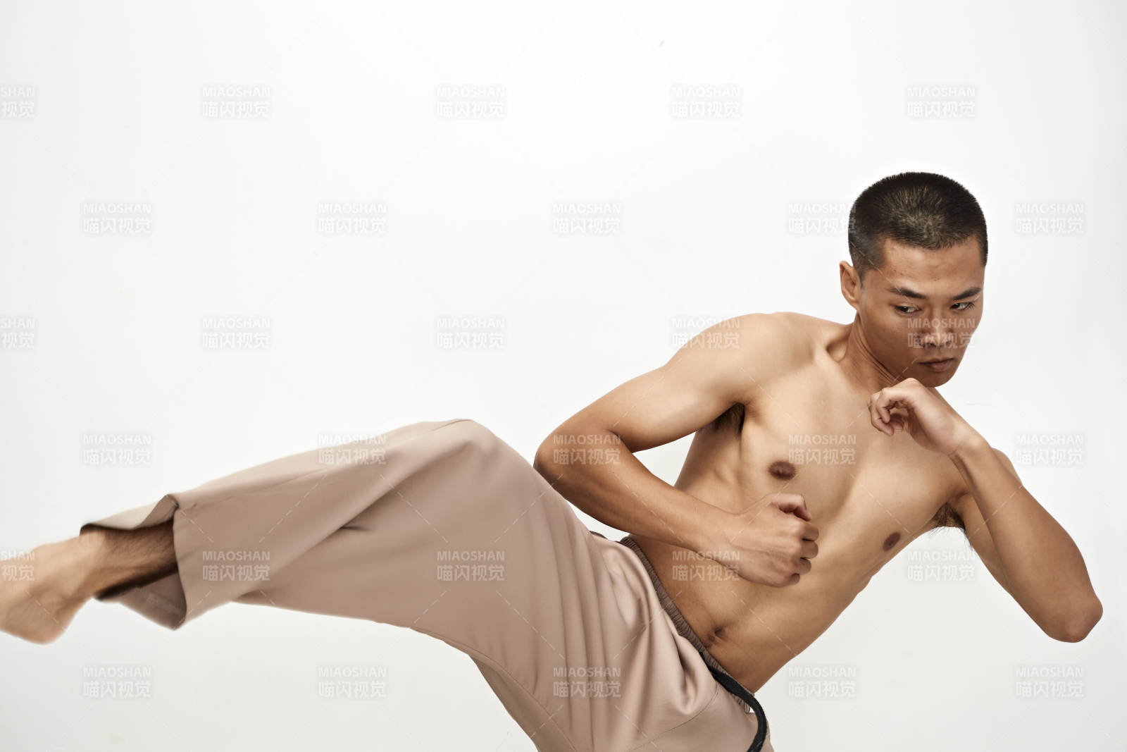白色背景下演示自由搏击动作的亚洲功夫男性图片