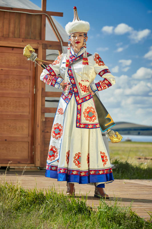 草原湖畔身穿蒙古族饰手持弓箭的蒙族少女图片