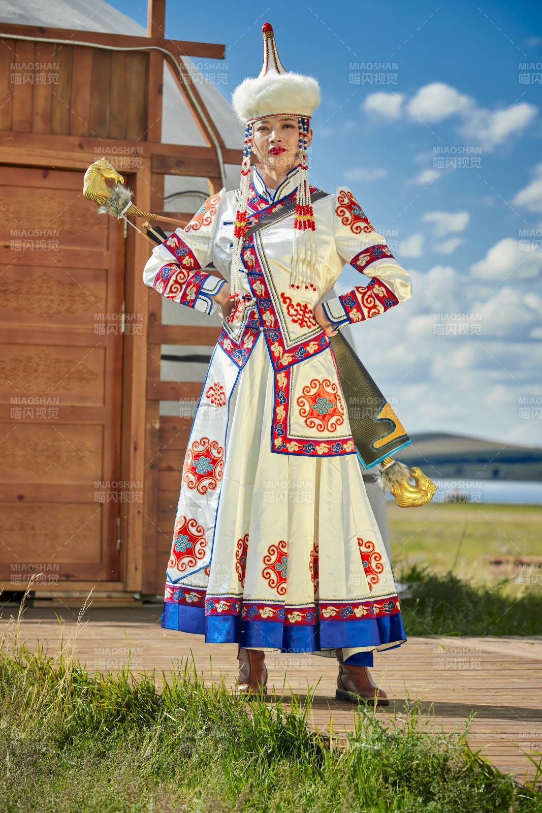 草原湖畔身穿蒙古族饰手持弓箭的蒙族少女图片