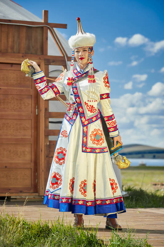 草原湖畔身穿蒙古族饰手持弓箭的蒙族少女图片