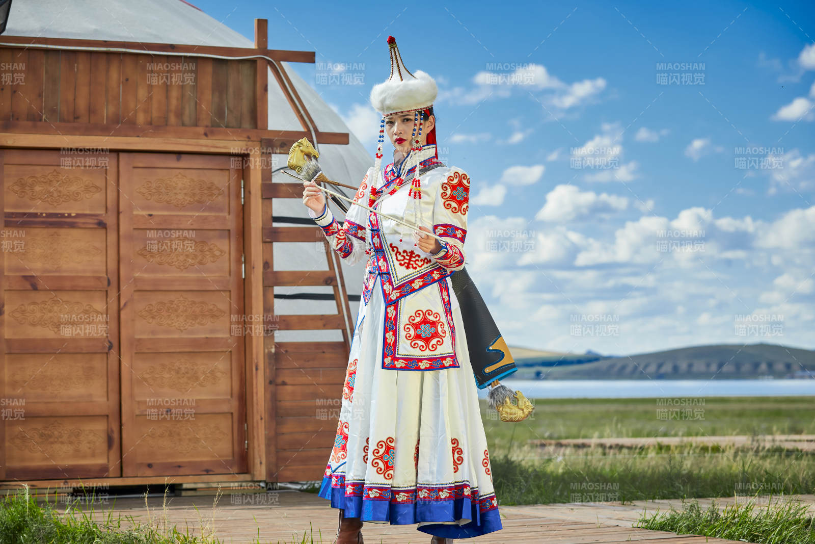 草原湖畔身穿蒙古族饰手持弓箭的蒙族少女图片